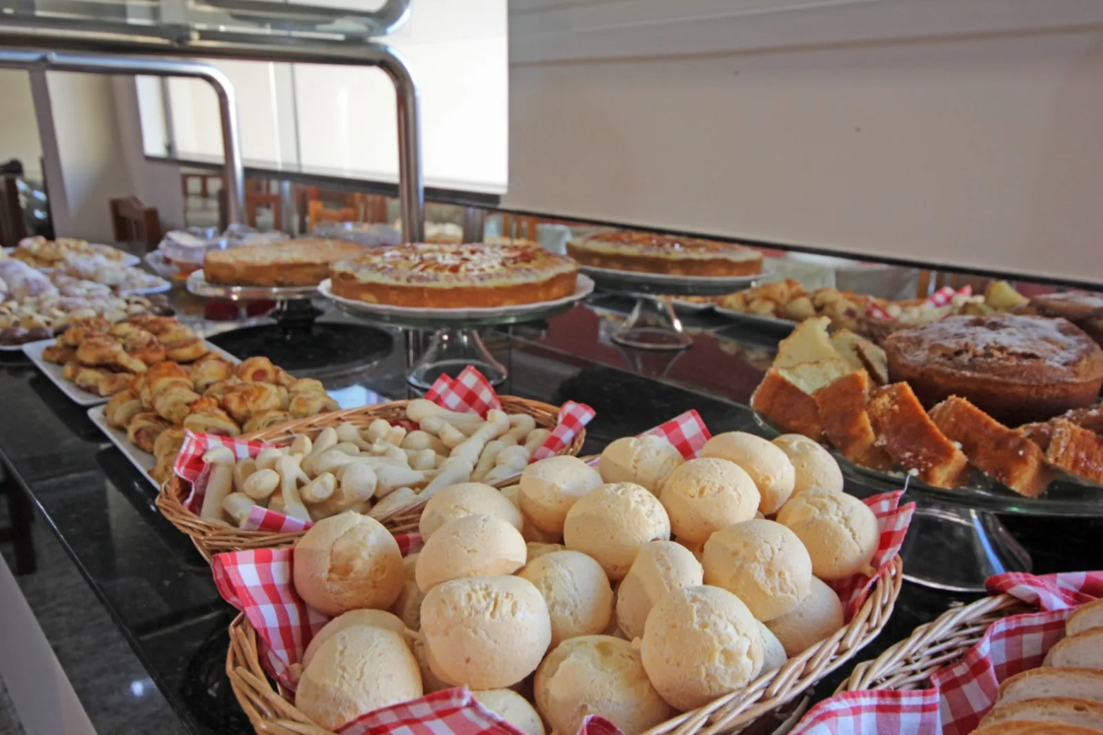 Mesa de coffee break montada pela Interativa Gourmet, com pão de queijo, salgados e bolos